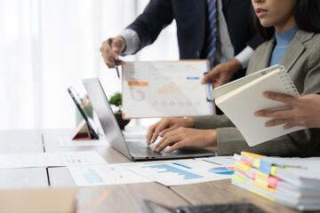 Two young Asian businesswoman discuss investment project working and planning strategy. Business people talking together with laptop computer at office.