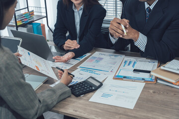 Businesswomen analyzing financial charts and data on desk