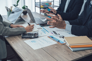 Businesswomen analyzing financial charts and data on desk