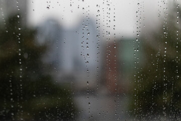 Rain droplets on glass with blurred cityscape

