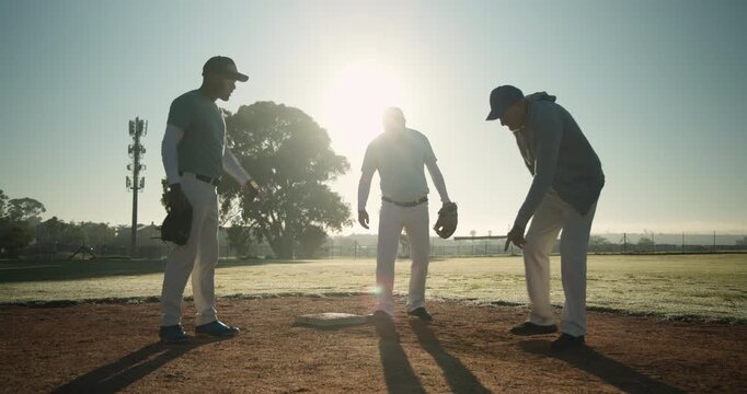 Senior white coach pointing and guiding diverse players positioning feet at first base