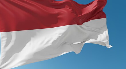 The Indonesian flag waving proudly in the morning air, isolated against a clear sky.