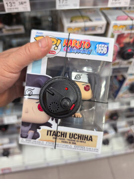 Holding a collectible Itachi Uchiha figure in a retail store