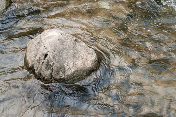 Mountain river. Big stones in a fast river. Texture of wet stones