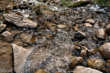 Mountain river. Large rocks in fast moving water. Texture of wet stones
