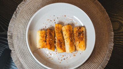 Crispy golden fried cassava sticks seasoned with aromatic spices and chili peppers. A perfect savory snack, ideal for Brazilian cuisine themes, street food, and appetizer menus.