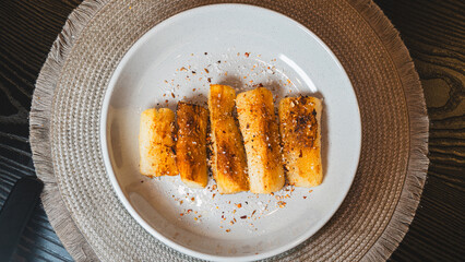 Crispy golden fried cassava sticks seasoned with aromatic spices and chili peppers. A perfect savory snack, ideal for Brazilian cuisine themes, street food, and appetizer menus.