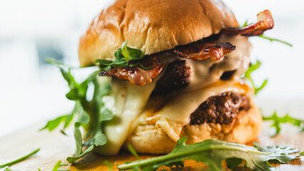 A towering double-deck bacon cheeseburger with juicy, rare beef patties, melted cheese, and crispy bacon. Perfect for gourmet burger spots, food blogs, and indulgent culinary content.