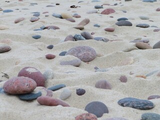 wallpaper of big colorful stones on the yellow sand beach