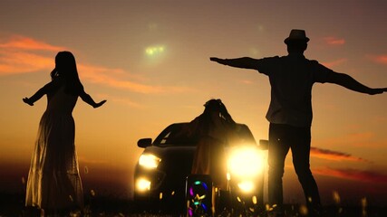 Happy family dancing at sunset near car silhouettes. Outstretched arms mom kid child daughter dad spinning dancing at dawn sunset to music. Great cheery nice memories family moments together road trip - Powered by Adobe