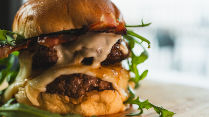 A towering double-deck bacon cheeseburger with juicy, rare beef patties, melted cheese, and crispy bacon. Perfect for gourmet burger spots, food blogs, and indulgent culinary content.