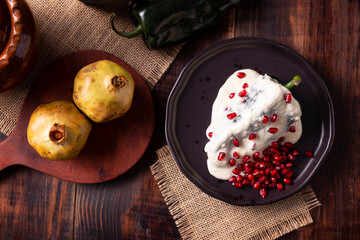 Chiles en Nogada, a typical Mexican dish. Poblano chile stuffed with meat and fruit, topped with a...