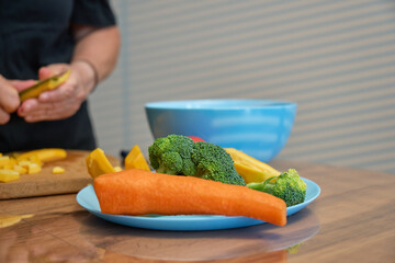Chopping fresh vegetables in a cozy kitchen with vibrant ingredients on a blue plate