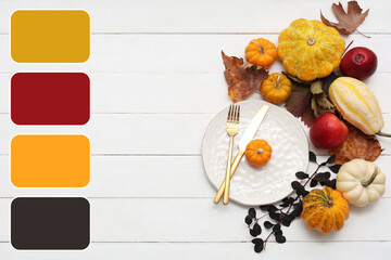 Beautiful table setting with autumn leaves, pumpkins and apples on white wooden background