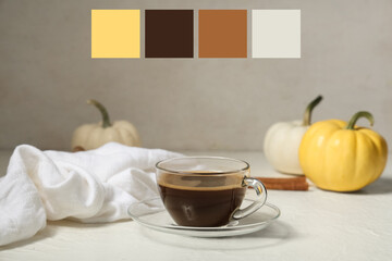 Cup of tasty pumpkin coffee with autumn decorations on grunge white background