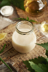 A jar of DIY shampoo made with nettle tea, argan oil, apple cider vinegar, lemon and coco glucoside. Alternative no poo haircare.
