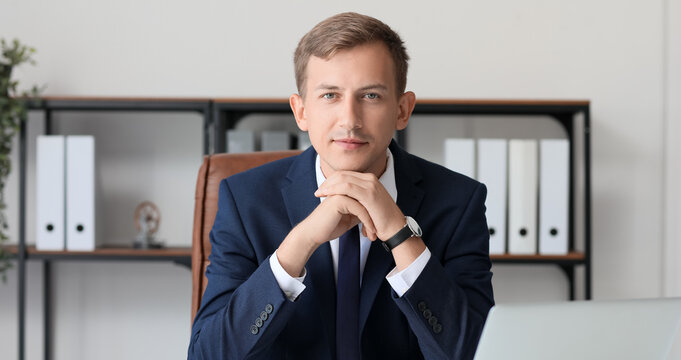 Young bank manager at table in office - Powered by Adobe