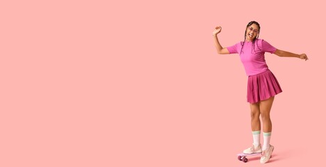 Happy African-American woman with skateboard on pink background with space for text