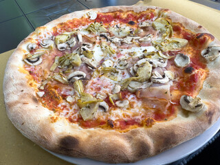 Delicious wood-fired pizza with artichokes and mushrooms