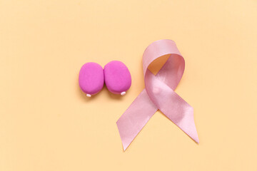 Female breast made of play dough and pink ribbon on color background. Breast cancer awareness concept