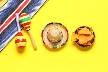 Mexican maracas with sombrero, nachos and serape on yellow background. Cinco de Mayo