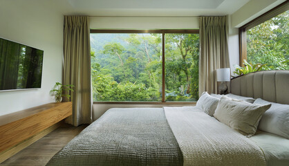 Modern bedroom with panoramic window overlooking tropical forest