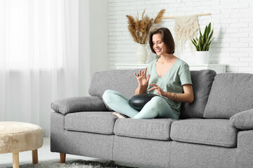 Fototapeta premium Young woman playing glucophone at home