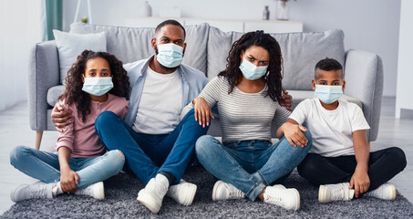 Preventive Measures Concept. Portrait of young African Amercian family of four people wearing...
