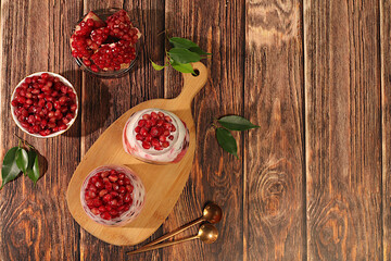 Fruit yogurt with pomegranate, raisins and fresh cow cream for healthy eating. Healthy breakfast with ingredients, kitchen background. Natural nutrition and detox diet concept, menu for cafe.