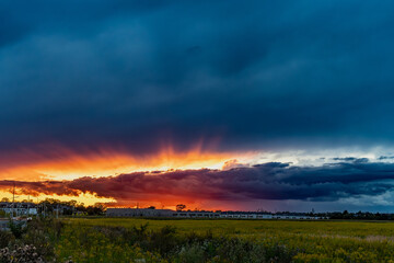 Dramatic sunset over field with colorful clouds