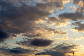 Colorful clouds fill the sky at sunset creating a stunning blend of orange and blue hues over the...