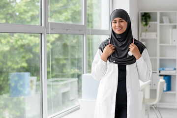 Female Muslim medical student with stethoscope in office