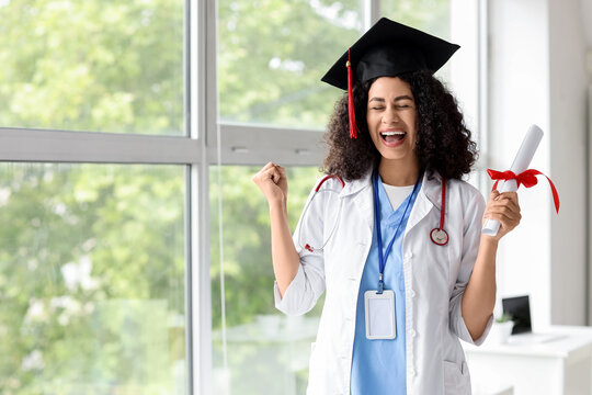 Happy female African-American medical student with graduation hat and diploma at university
