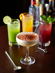 Assortment of colorful cocktails on a dark wooden surface