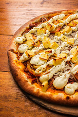 Artisan pizza with melted cheese, shredded beef, and fresh tomatoes