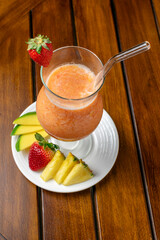 Healthy detox berry smoothie with fresh ingredients such as strawberry, pineapple, and mango, a...