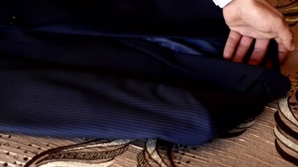 A man, dressed in a white shirt and tie, adjusts his tie as he prepares for a special occasion, possibly his wedding day. - Powered by Adobe