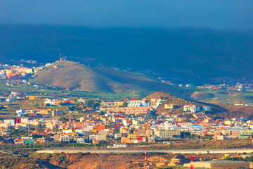 Colorful buildings cluster along rolling hills of Tenerife