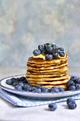 Stack of fresh hot banana pancakes with maple syrup and blueberries for a breakfast.
