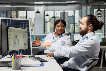 Team working together in office to optimize sustainable solar panel fabrication with advanced...