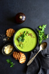 Green pea soup with parmesan and croutons . Top vie with copy space.