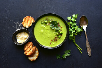 Green pea soup with parmesan and croutons . Top vie with copy space.