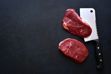 Raw organic marbled beef steaks with ingredients for cooking . Top view with copy space.