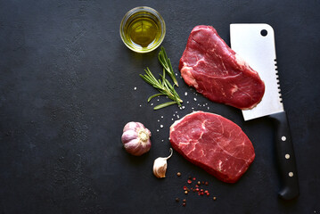 Raw organic marbled beef steaks with ingredients for cooking . Top view with copy space.