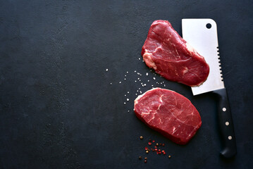 Raw organic marbled beef steaks with ingredients for cooking . Top view with copy space.