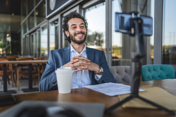 Businessman streaming live video on social media from cafe