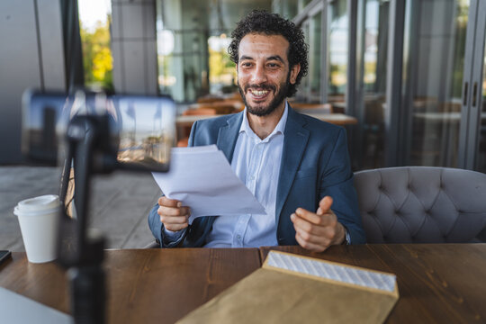 Businessman recording video blog about financial report using smart phone