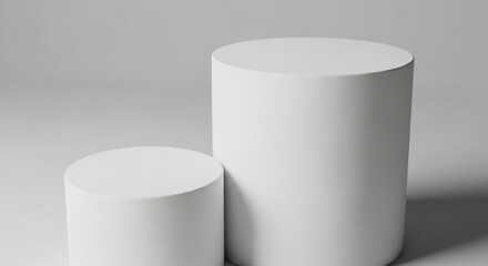 Two white cylindrical pedestals on a gray background, offering a clean, minimalist product display showcase ideal for advertising or branding mockupsFree space for text or logo placement