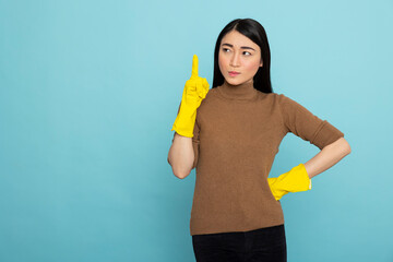 Young female housekeeper gestures upward with index finger, indicating isolated copy space for...