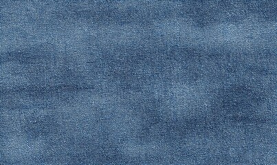 Close-up of a textured, slightly wrinkled, denim fabric in varying shades of blue. The image shows the woven structure and subtle color variations inherent in the material